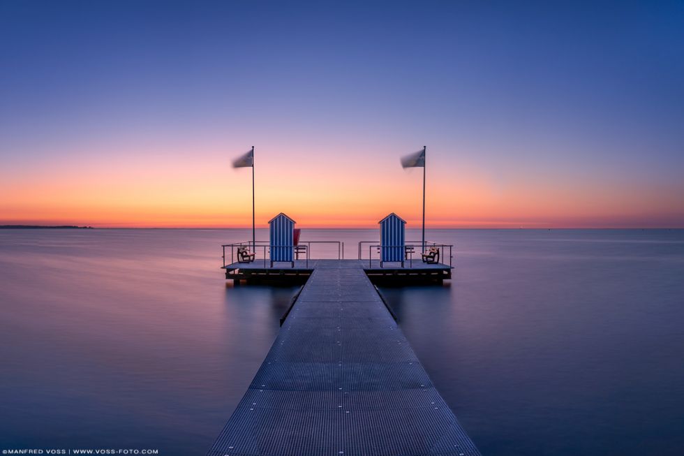 Schöner Badesteg an der Kieler Förde beim Ort Stein im stimmungsvollen Sonnenuntergang.