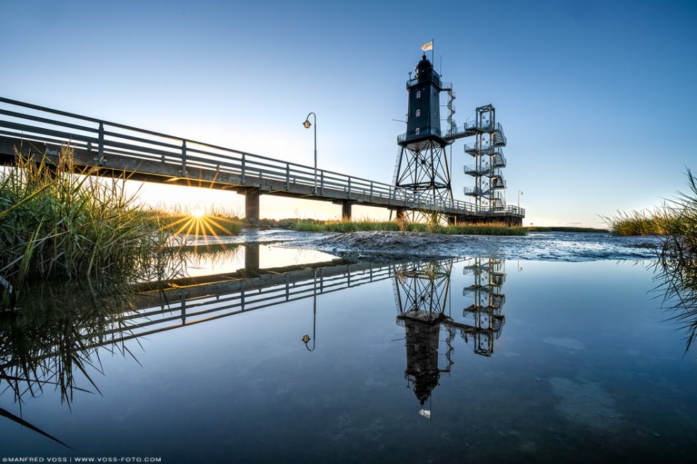 * Obereversand * Der Leuchtturm Obereversand an der Nordsee. Sanft und anmutig spiegelt sich der Leuchtturm sowie die untergehende Sonne im zurücklaufenden Meer.