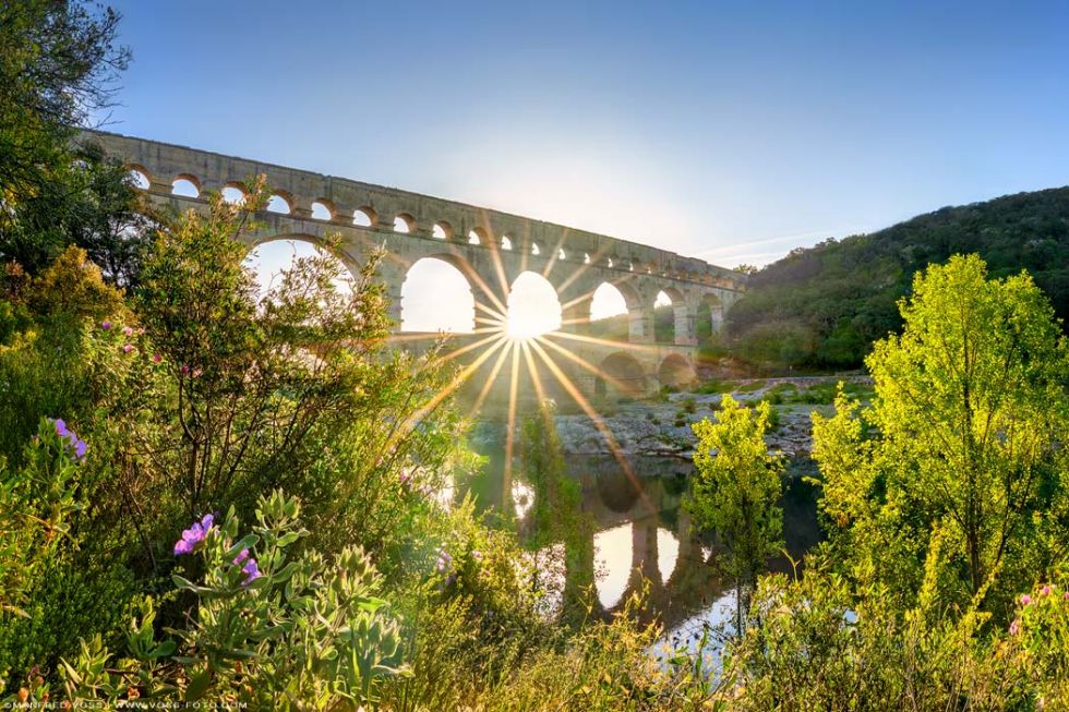 * Sunrise Bridge * Die historische Pont du Gard Brücke in Frankreich mit dem Fluss Gard ( Gardon ) eingebettet ein eine schöne Natur Landschaft. Römischer Aquädukt in Südfrankreich in Department Gard in Okzitanien.