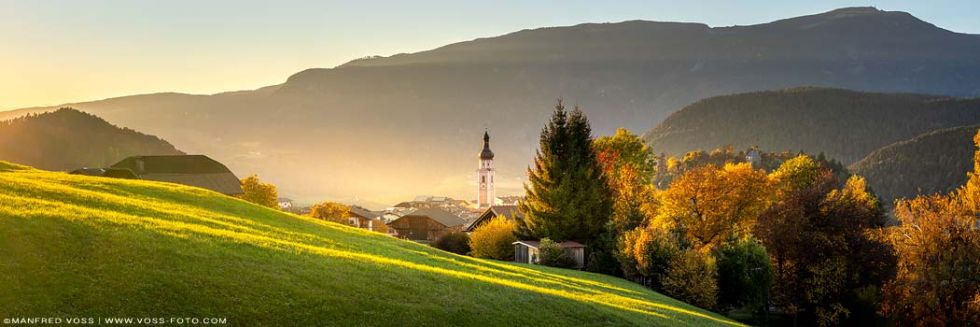 Kastelruth im goldenen Herbst. Sonnenuntergang beim Ort Kastelrut in Südtirol am Schlerngebiet in den Dolomiten