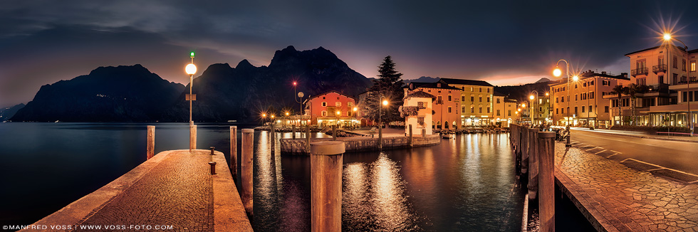 Panorama vom Ort Torbole am Gardasee in Italien im stimmungsvollen Abendlicht .
